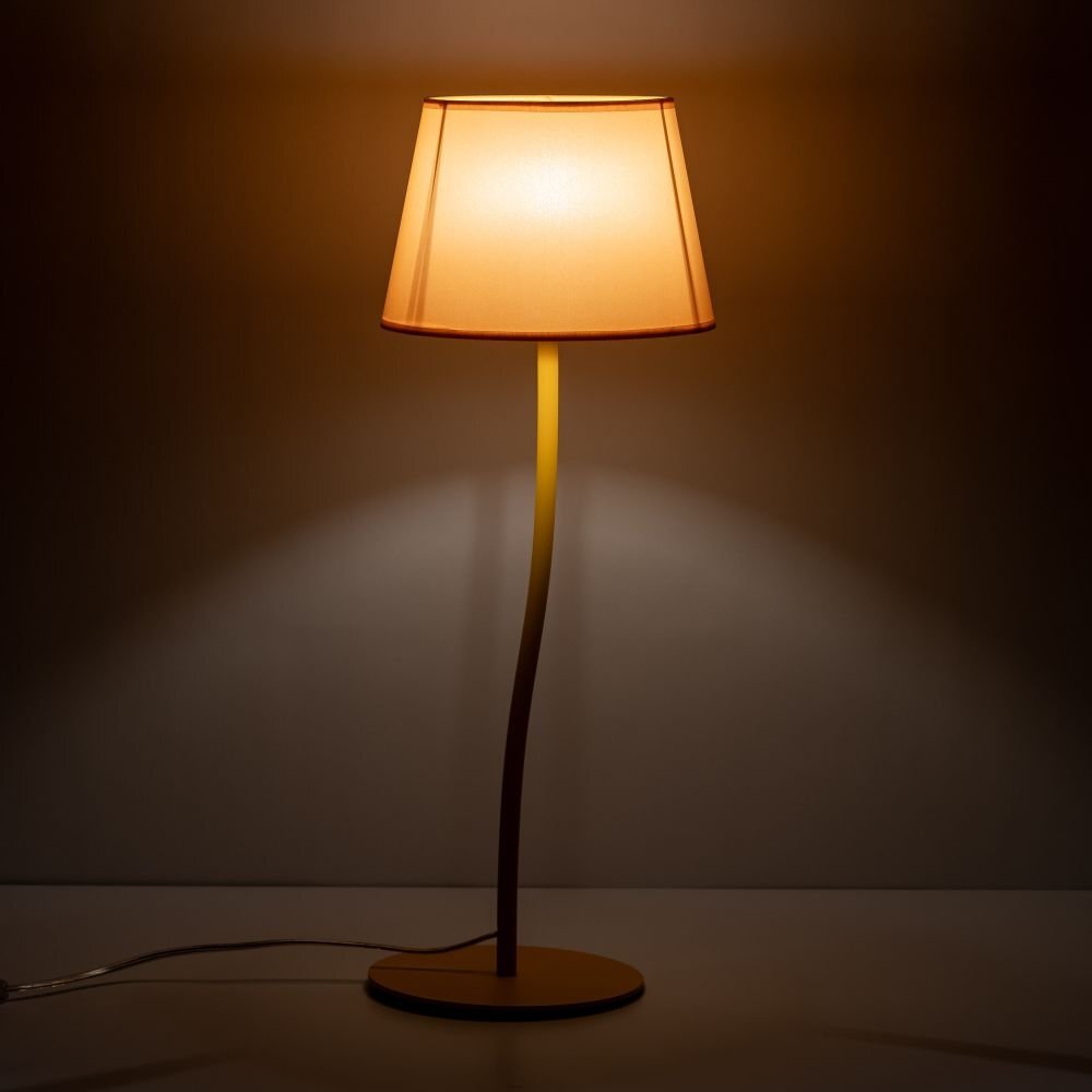 Na obrazie widoczna jest lampa stołowa z żółtym abażurem, emitująca ciepłe światło. Lampa ma smukłą, zakrzywioną podstawę i stoi na płaskiej powierzchni.