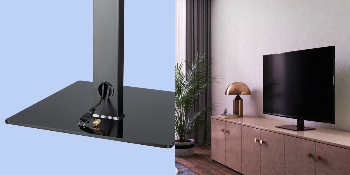 Po lewej stronie widać czarną podstawę stojaka z przewodami, po prawej telewizor na stojaku umieszczony na szafce w salonie z rośliną i lampą.