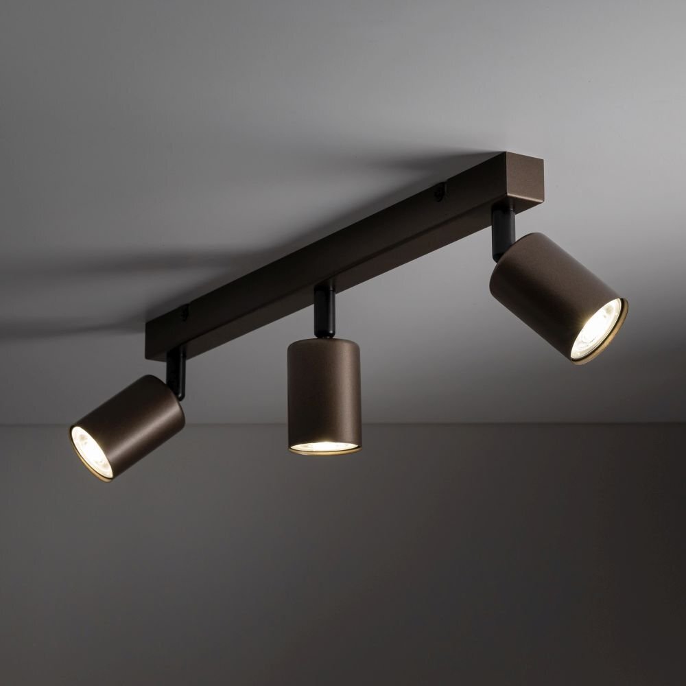 Brązowa lampa sufitowa z trzema regulowanymi reflektorami LED zamontowana na prostokątnej listwie. Reflektory są skierowane w różnych kierunkach, a światło jest włączone.