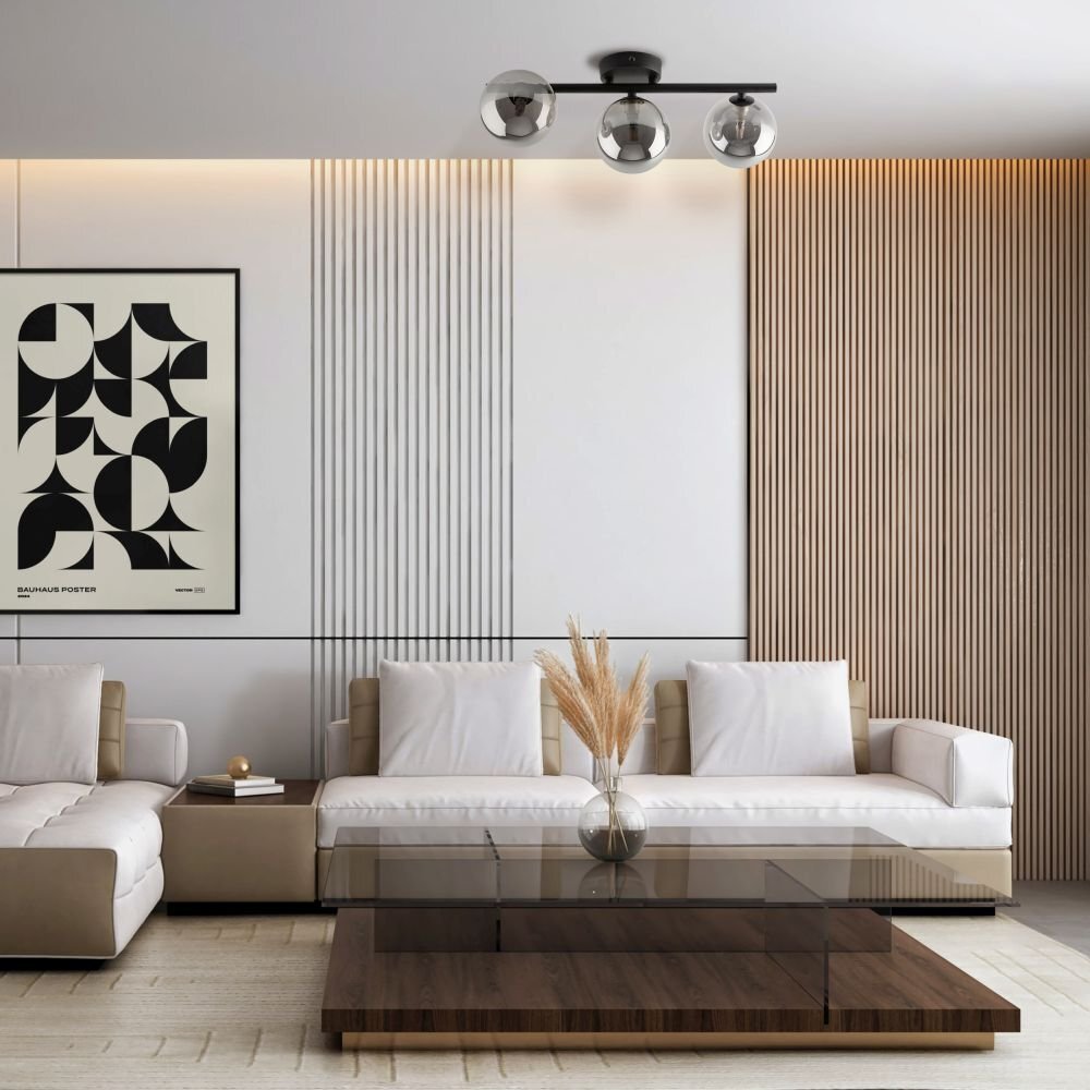 Nowoczesny salon z białą sofą i drewnianym stolikiem kawowym, na suficie zamontowana jest czarna lampa z trzema szklanymi kloszami. Na ścianie wisi plakat z abstrakcyjnym wzorem i napisem \'BAUHAUS POSTER\'.