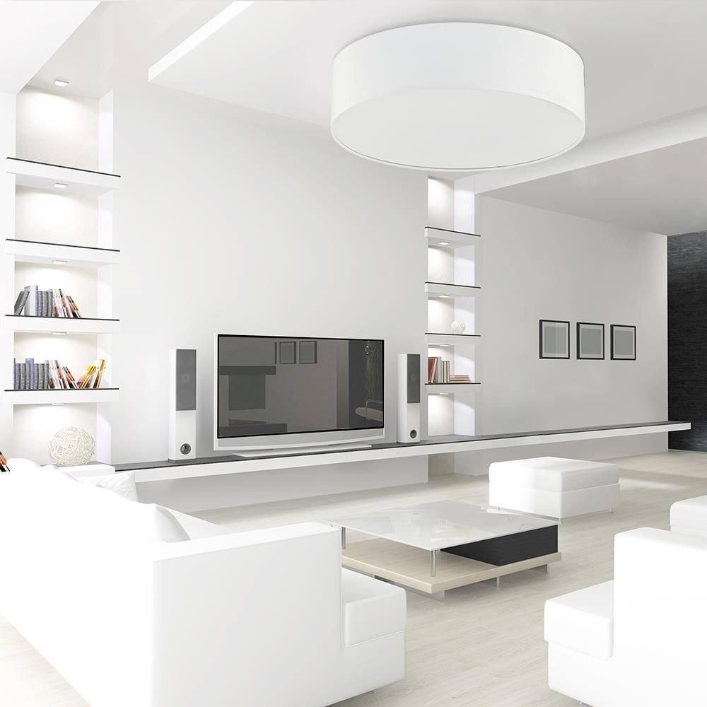 Nowoczesny salon z białymi meblami, dużym telewizorem i półkami z książkami. Na suficie zamontowany jest biały plafon o prostym, eleganckim designie.