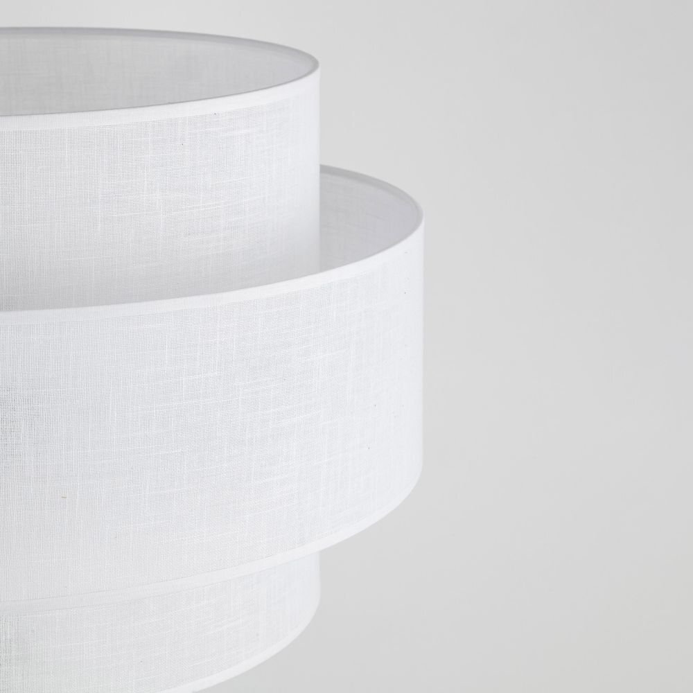 Biały abażur lampy podłogowej o nowoczesnym designie, wykonany z materiału o delikatnej fakturze. Abażur ma cylindryczny kształt i jest widoczny na neutralnym tle.
