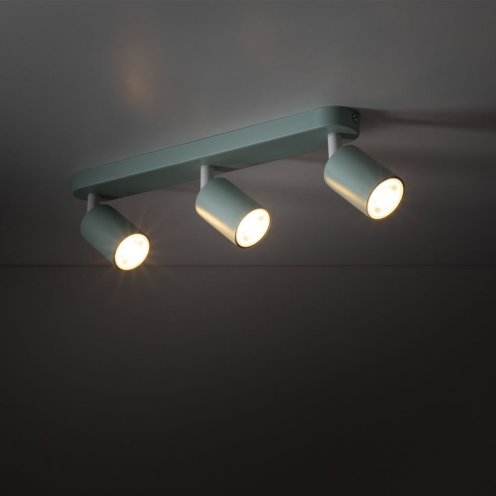 Na obrazie widoczna jest miętowa lampa sufitowa z trzema regulowanymi reflektorami, zamontowana na suficie. Reflektory emitują ciepłe światło.