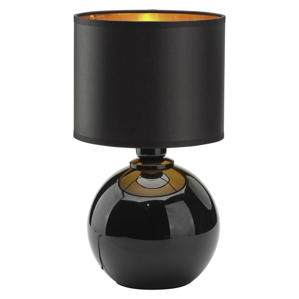 Czarna lampa stołowa z okrągłą podstawą i cylindrycznym abażurem, wewnątrz złotym. Powierzchnia lampy jest błyszcząca, odbijająca światło.