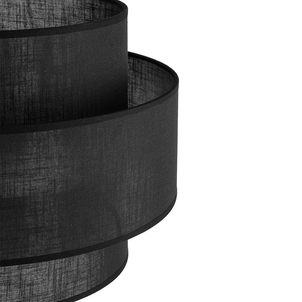 Czarny abażur lampy podłogowej wykonany z materiału, o cylindrycznym kształcie z widoczną teksturą tkaniny.