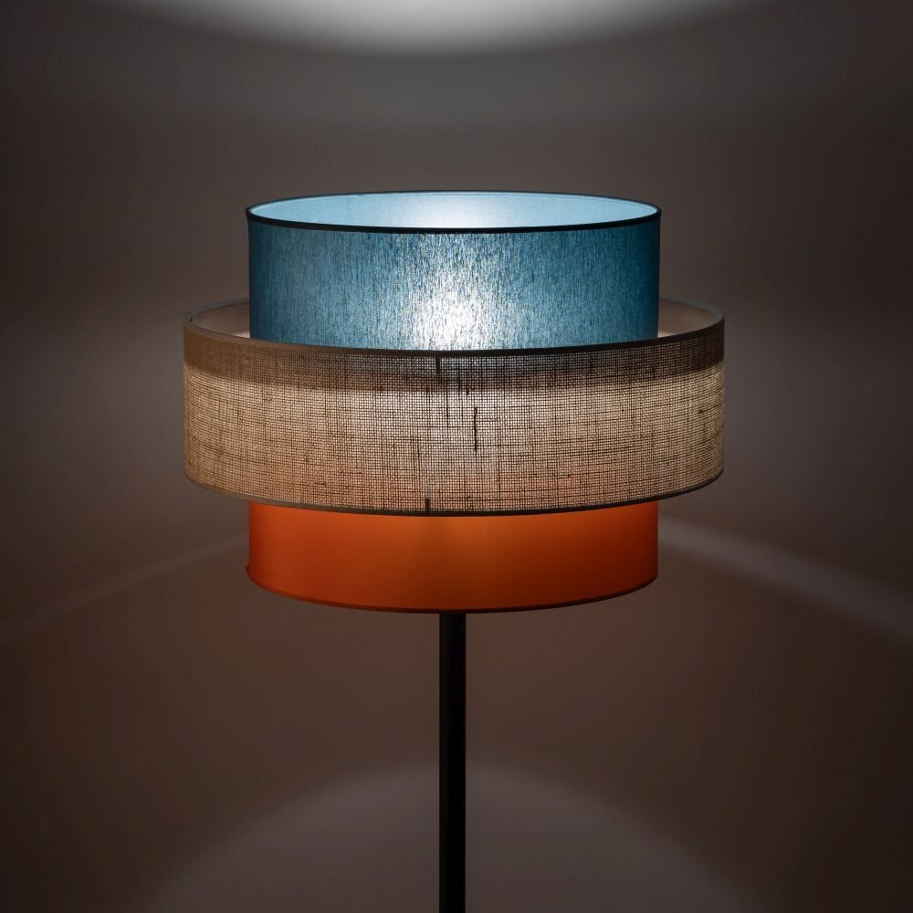 Lampa podłogowa z trzema abażurami w kolorach niebieskim, beżowym i pomarańczowym. Abażury mają cylindryczny kształt i są umieszczone jeden nad drugim.