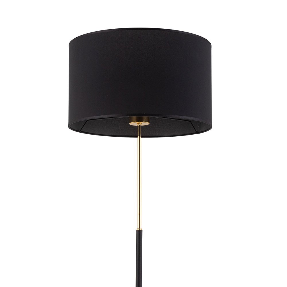 Czarna lampa podłogowa z cylindrycznym abażurem i złotym trzonkiem. Lampa ma nowoczesny design i włącznik sznurkowy.