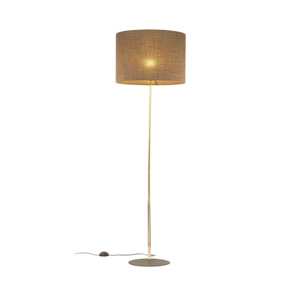 Lampa podłogowa z cylindrycznym abażurem w kolorze brązowym, na smukłej, złotej nodze z okrągłą podstawą. Przewód z włącznikiem widoczny na podłodze.
