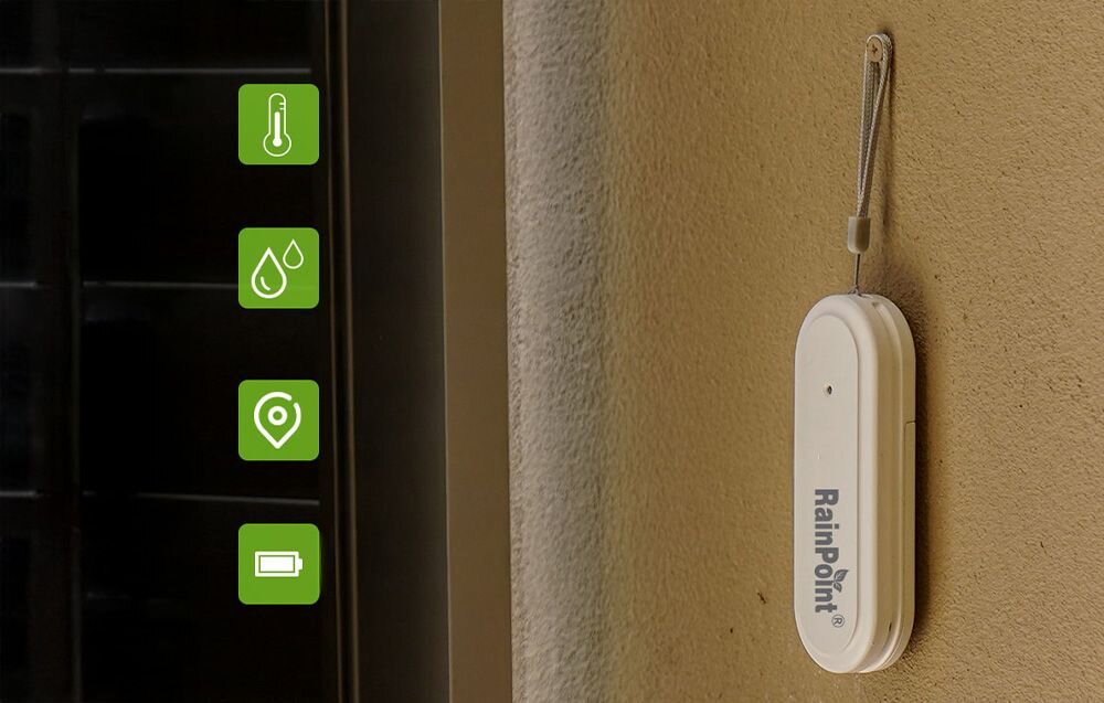 Inteligentny Termohigrometr RAINPOINT Smart+, termohigrometr, temperatura, wilgotność, monitoring, Czujnik RainPoint przymocowany do beżowej elewacji, z boku widoczne ikony temperatury, wilgotności i baterii.