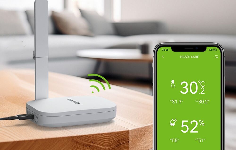 Inteligentny Termohigrometr RAINPOINT Smart+, zakres temperatur, wilgotność, pomiar, otoczenie, Stacja bazowa na stole oraz ekran telefonu z aplikacją wyświetlającą temperaturę 30,2°C i wilgotność 52%.