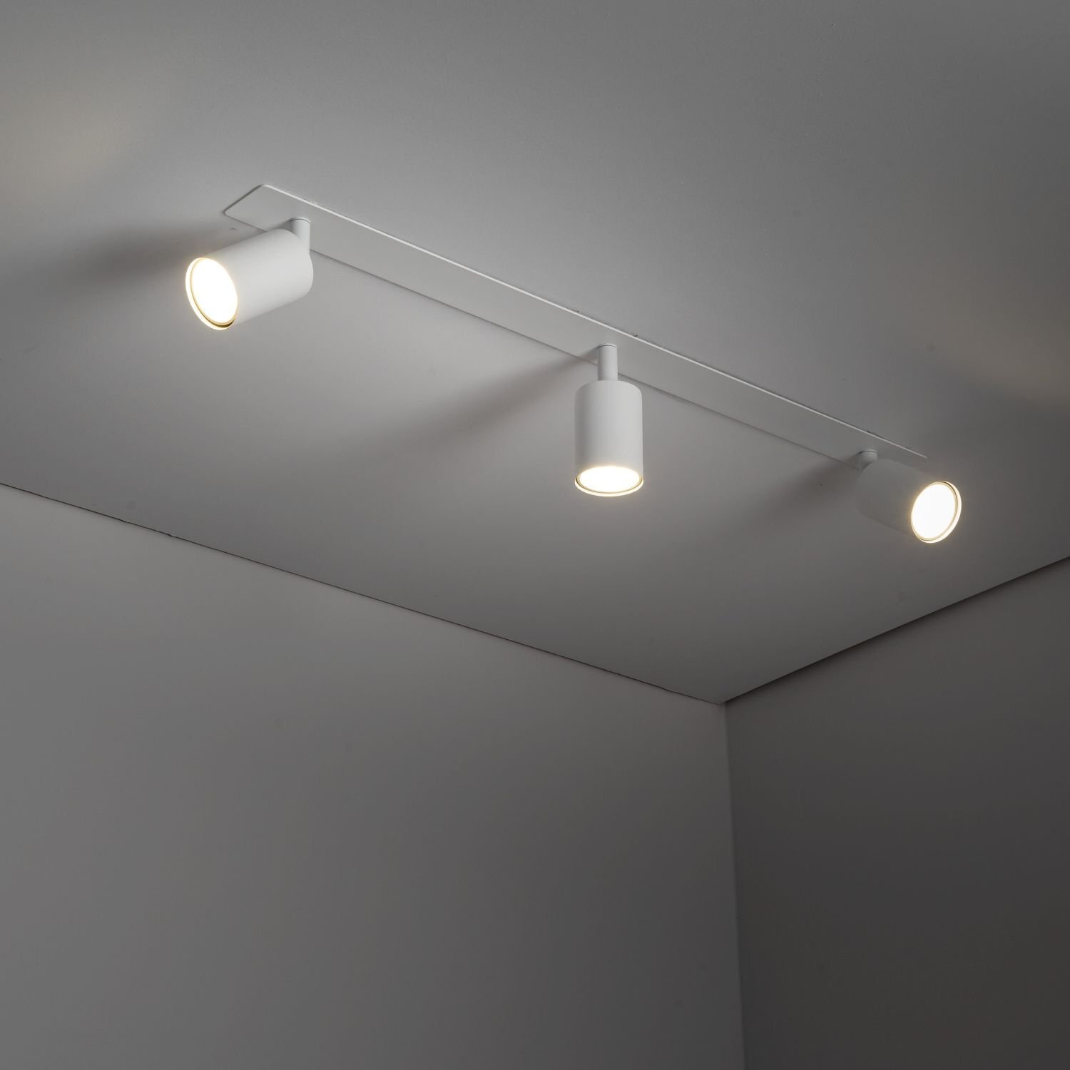 Na suficie zamontowany jest biały reflektor podtynkowy z trzema regulowanymi spotami. Każdy spot emituje światło, a całość ma nowoczesny design.