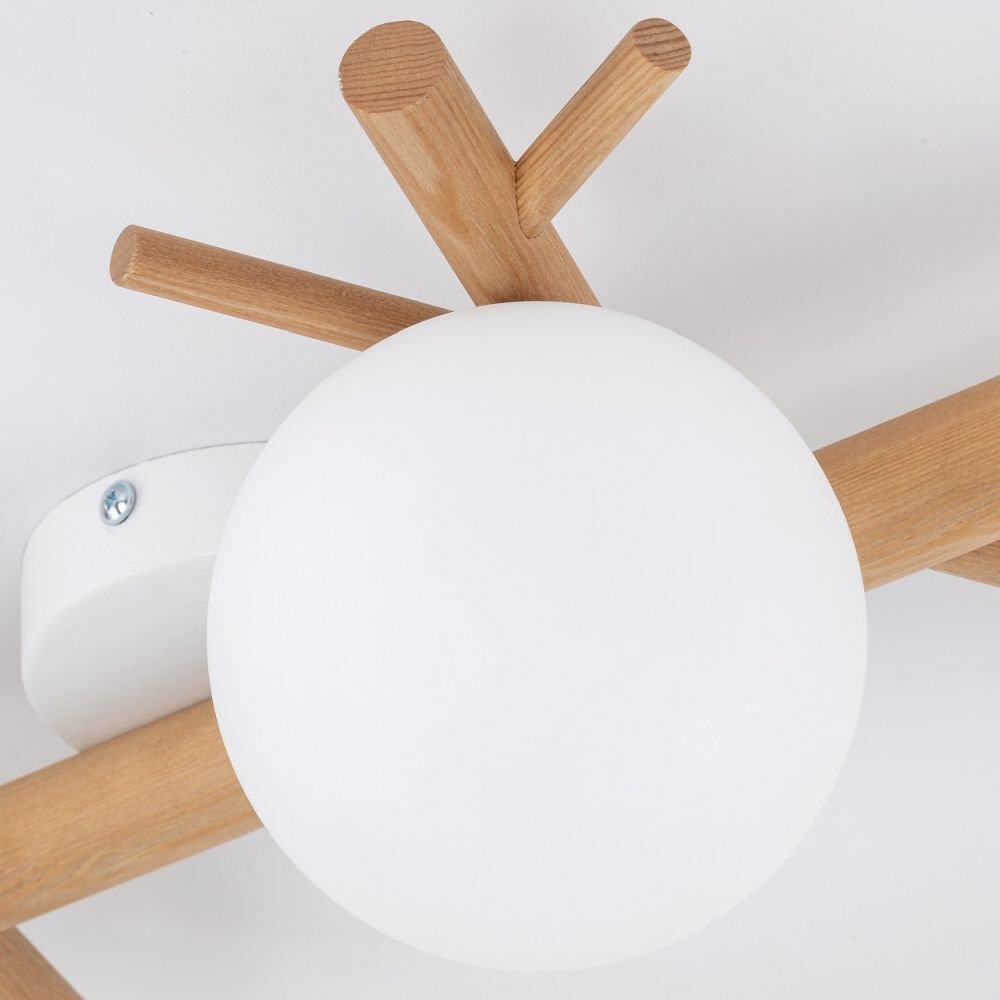 Lampa sufitowa z białym, kulistym kloszem i drewnianymi elementami. Widoczny jest również metalowy uchwyt montażowy z wkrętem.