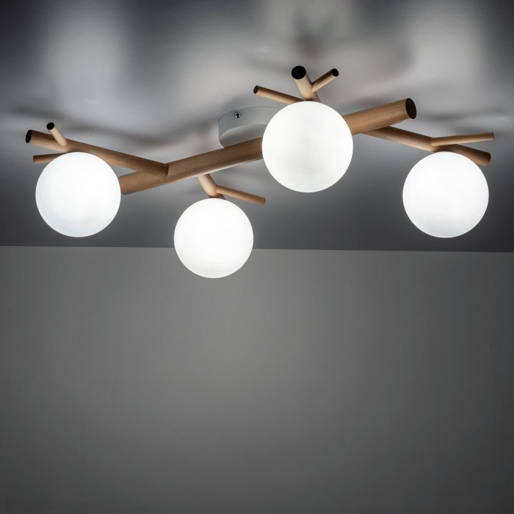 Lampa sufitowa z czterema kulistymi kloszami w kolorze białym, zamontowana na drewnianej konstrukcji przypominającej gałęzie. Klosze są równomiernie rozmieszczone, a całość przymocowana jest do sufitu.