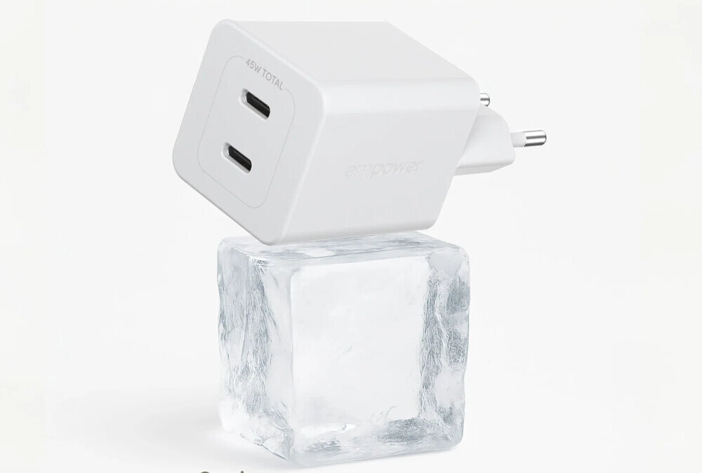 Biała ładowarka sieciowa z dwoma portami USB-C oznaczona napisem \'45W TOTAL\' leży na kostce lodu. Na boku ładowarki widoczny jest napis \'empower\'.