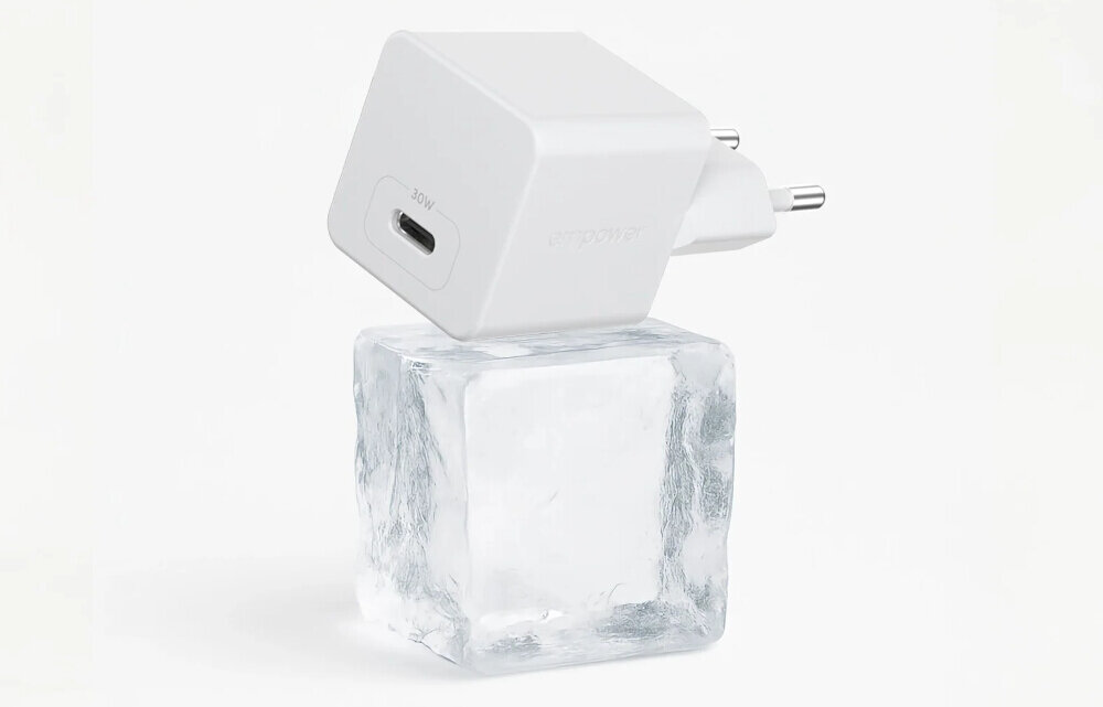 Biała ładowarka sieciowa z wtyczką i portem USB-C oznaczonym jako 30W, umieszczona na przezroczystej kostce lodu.