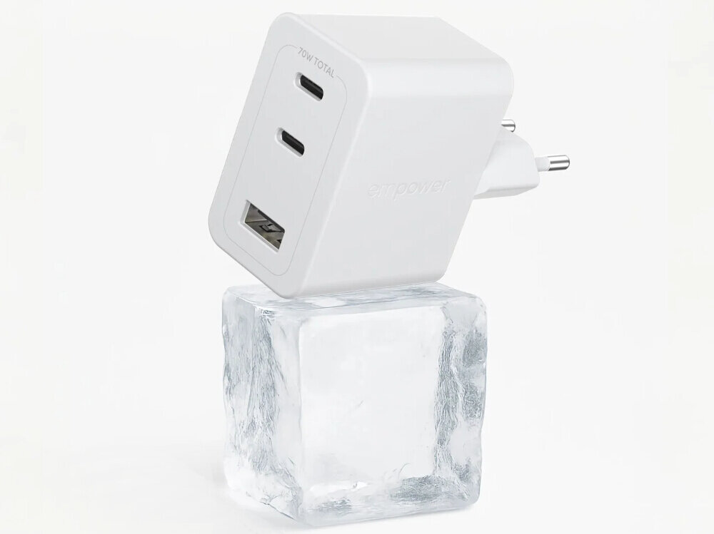 Biała ładowarka sieciowa z dwoma portami USB-C i jednym USB, oznaczona napisem \'70W TOTAL\' oraz \'empower\', stoi na przezroczystej kostce lodu.