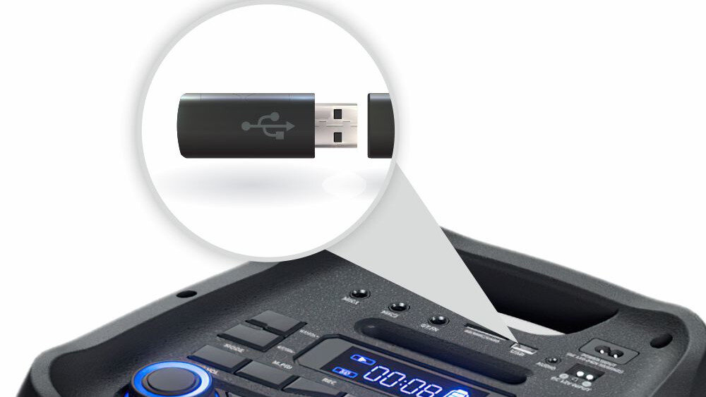 Obraz przedstawia górną część urządzenia audio z widocznymi przyciskami i wyświetlaczem. W powiększeniu pokazany jest czarny pendrive z symbolem USB.