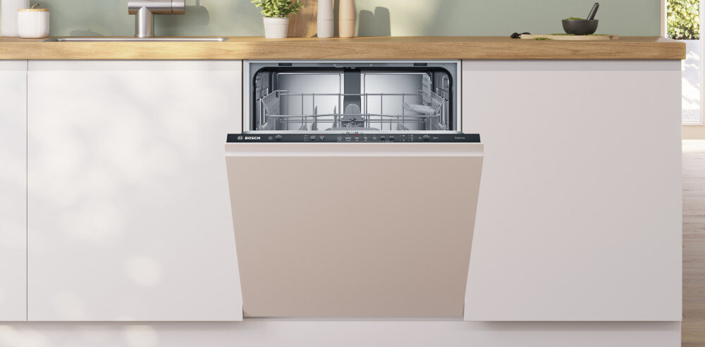 Zmywarka w zabudowie kuchennej z otwartymi drzwiami, ukazująca wnętrze z koszami na naczynia. Na panelu widoczne jest logo BOSCH.