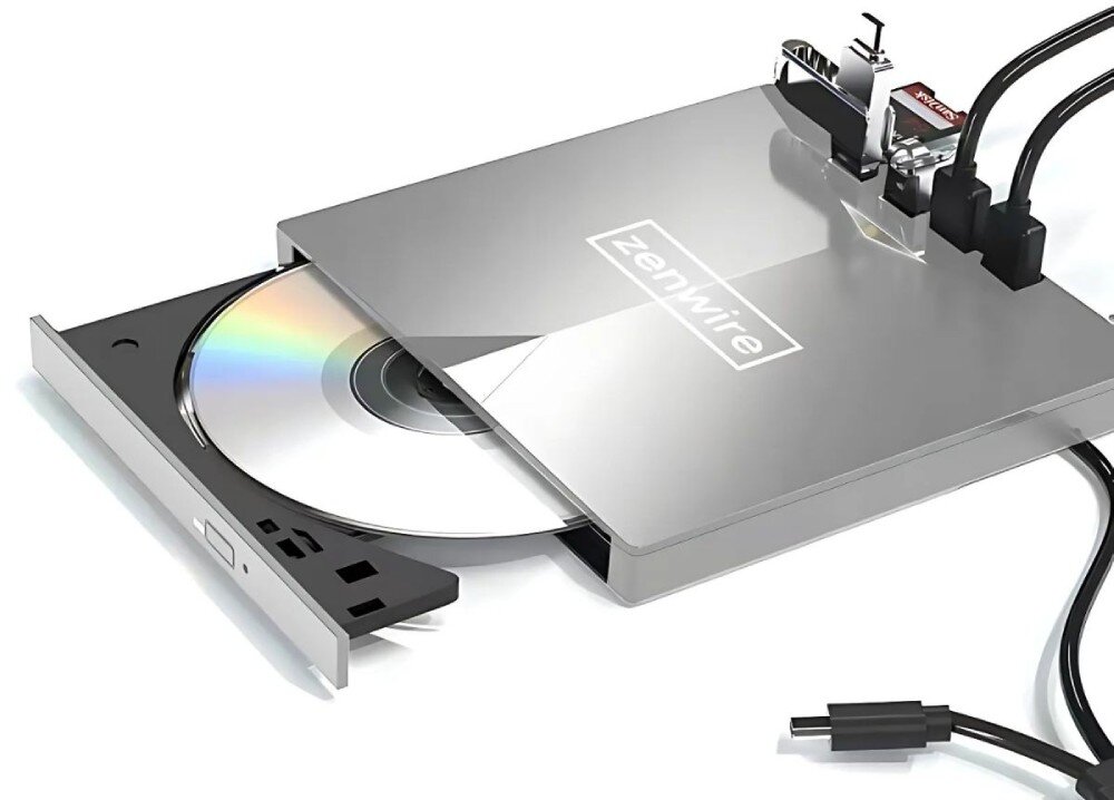 Na obrazie widoczny jest zewnętrzny napęd optyczny z wysuniętą tacką, na której znajduje się płyta CD. Na obudowie napędu widnieje logo \'ZenWire\'.
