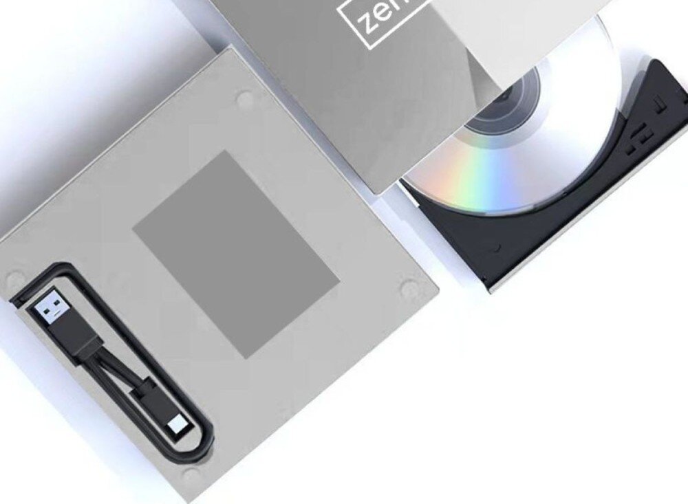 Obraz przedstawia otwarty napęd optyczny z widoczną płytą CD oraz kabel USB umieszczony w specjalnym wgłębieniu. Na obudowie napędu widoczne jest logo \'zenwire\'.