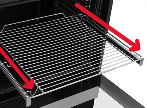 Zdjęcie przedstawia metalowy ruszt piekarnika wysunięty na teleskopowych prowadnicach. Na ruszcie znajdują się czerwone strzałki wskazujące kierunek wysuwania.