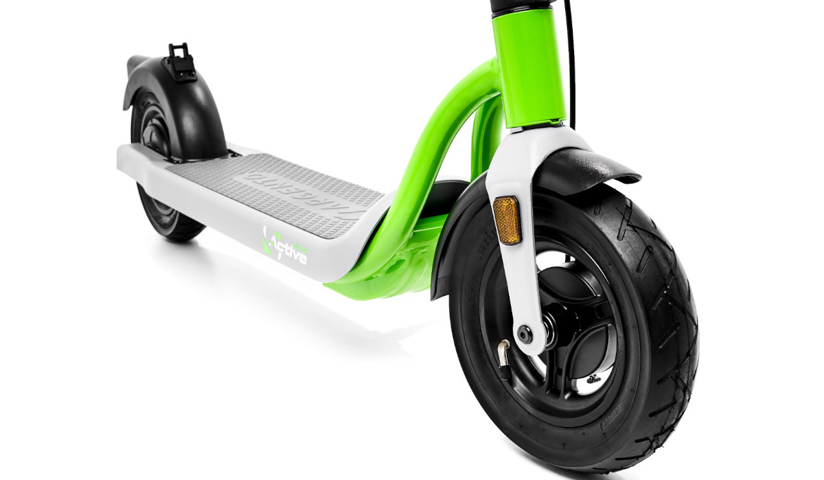 Na zdjęciu widoczna jest część hulajnogi elektrycznej w kolorach czarnym, zielonym i szarym, z dużym przednim kołem i amortyzatorem. Na podeście znajduje się napis \'Evo Active\'.