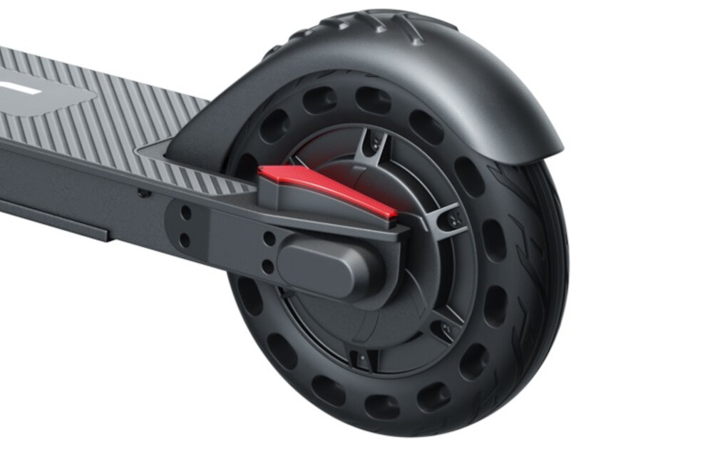 Obraz przedstawia tylne koło hulajnogi elektrycznej z czarną oponą i czerwonym elementem przy hamulcu. Koło ma otwory wzdłuż krawędzi, a nad nim znajduje się błotnik.