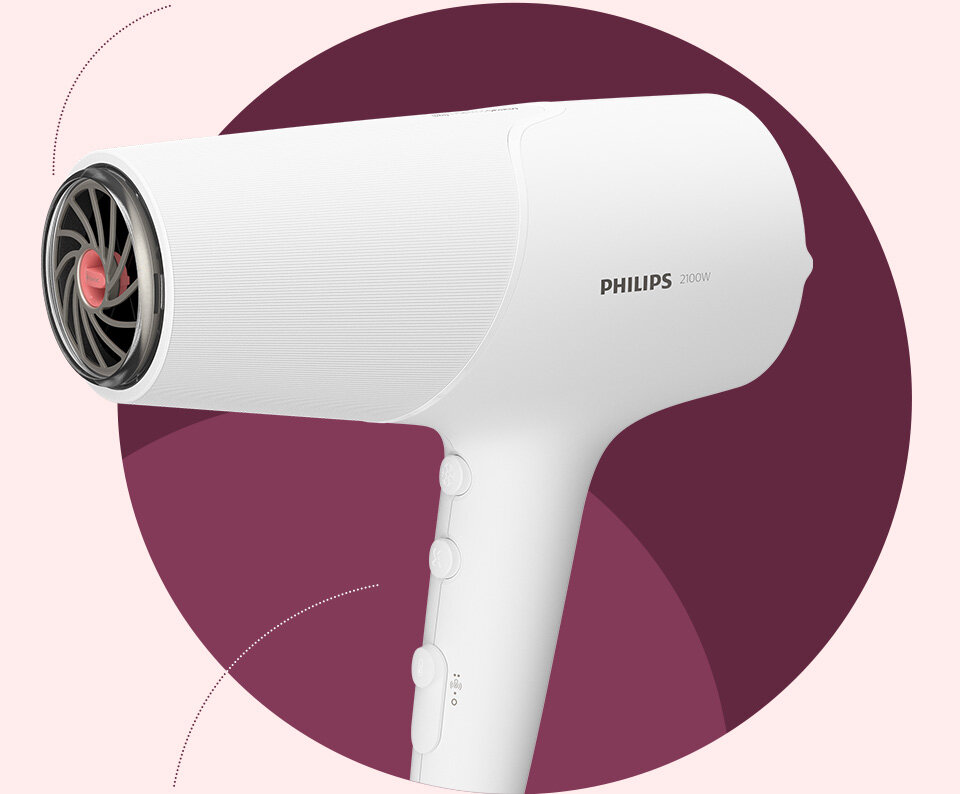 Biała suszarka do włosów z widocznym logo \'PHILIPS 2100W\' na uchwycie. W tle znajduje się okrągły, bordowy kształt.