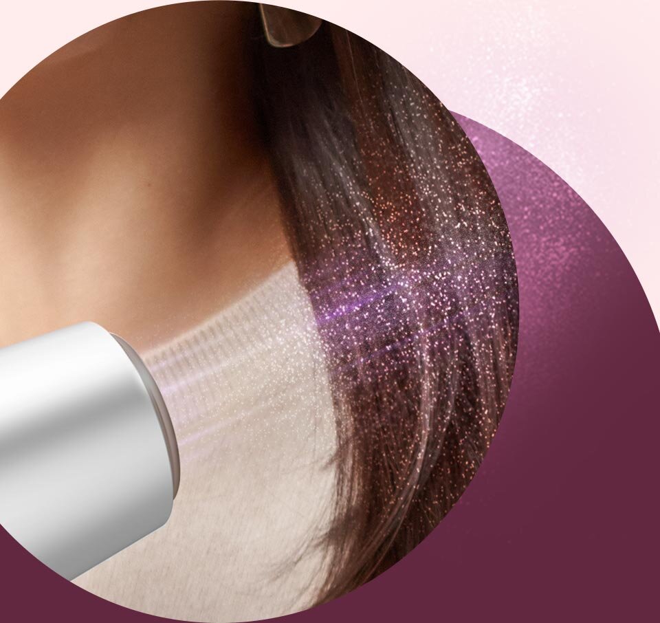 Obraz przedstawia suszarkę do włosów skierowaną na długie, ciemne włosy, które są lśniące i gładkie. W tle widoczny jest gradient w odcieniach różu i fioletu.