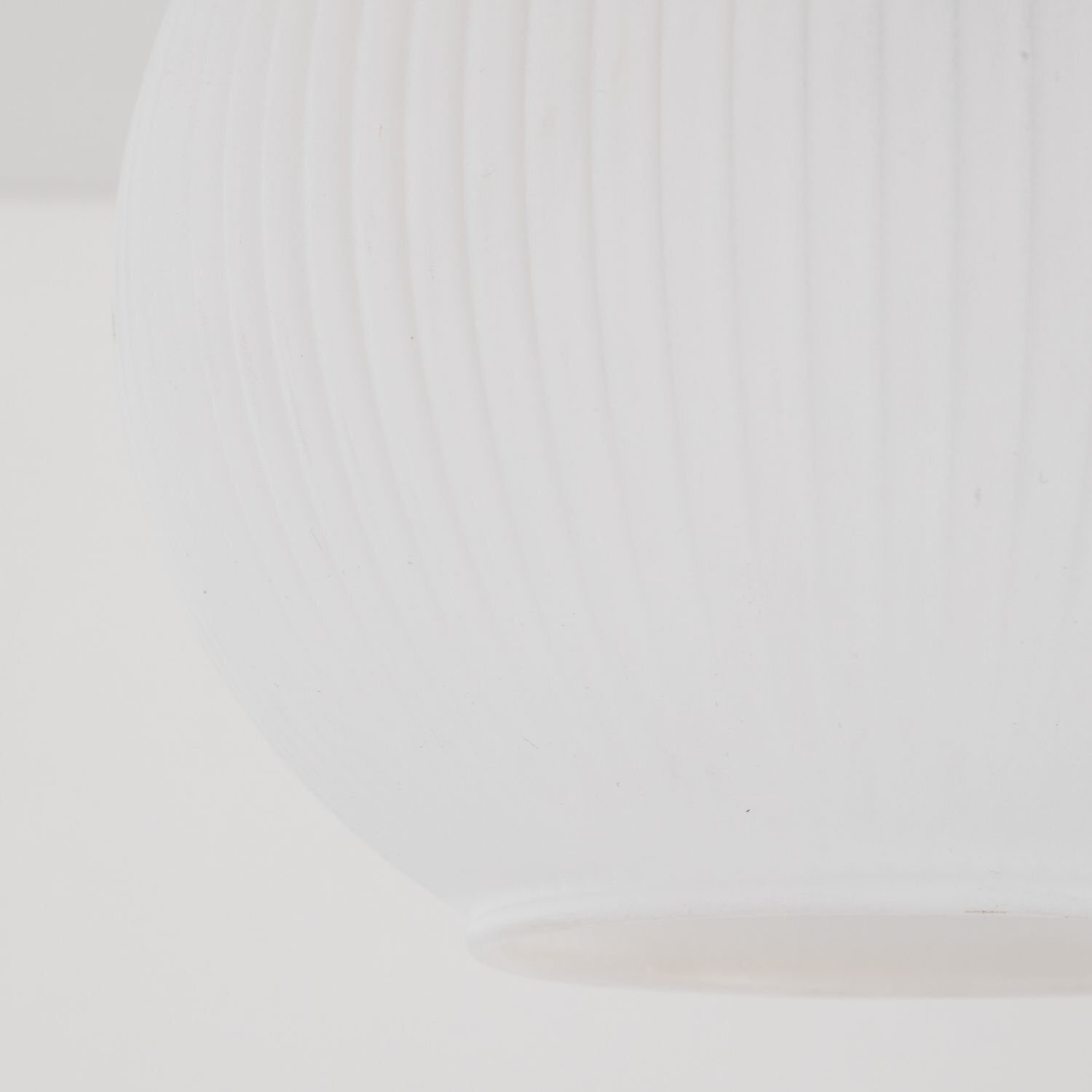 Biała, metalowa lampa sufitowa o nowoczesnym designie z widocznymi pionowymi żłobieniami na powierzchni. Lampa ma kształt półkuli i jest przeznaczona do montażu na suficie.