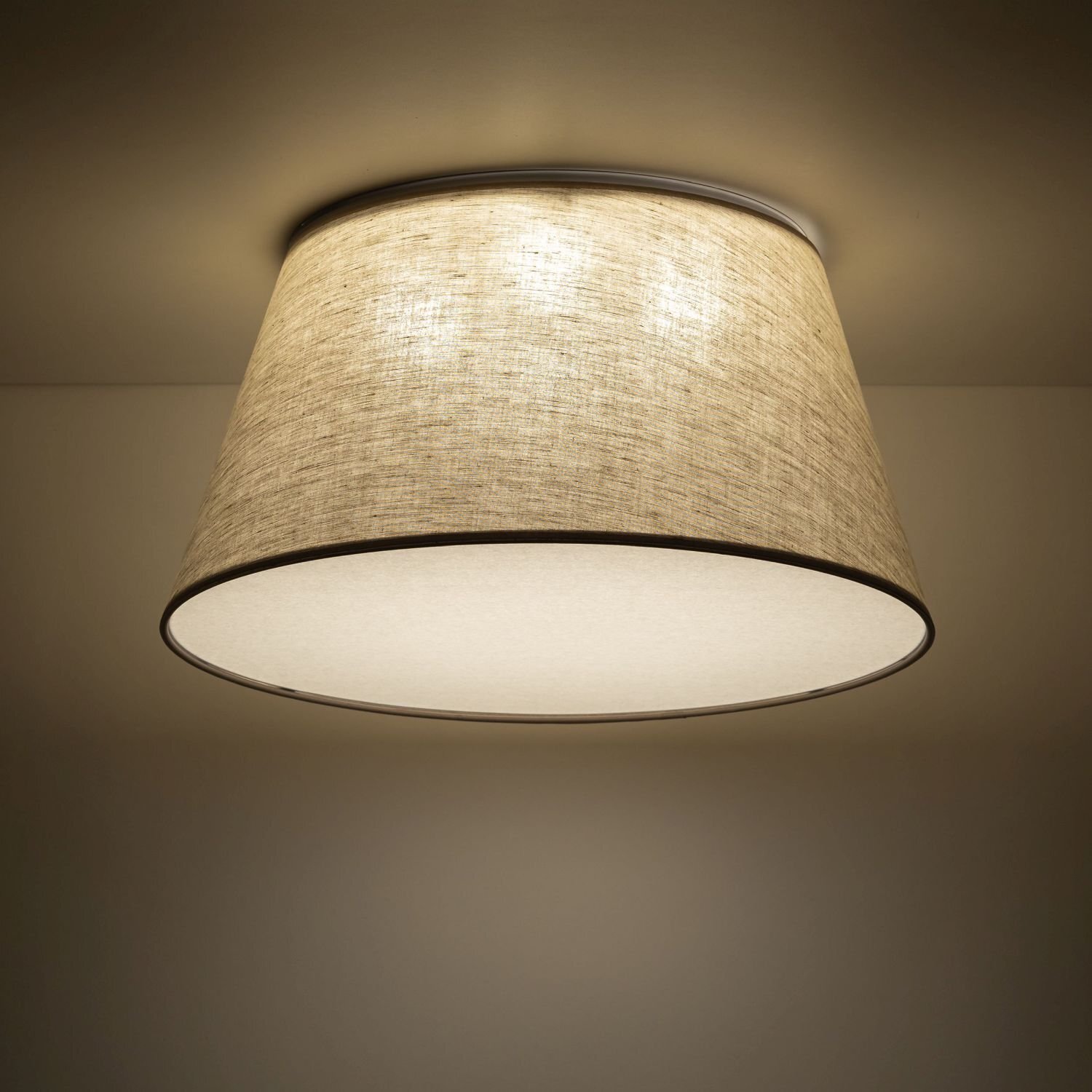Lampa sufitowa z beżowo-białym, lnianym kloszem o nowoczesnym designie. Emituje ciepłe, rozproszone światło.