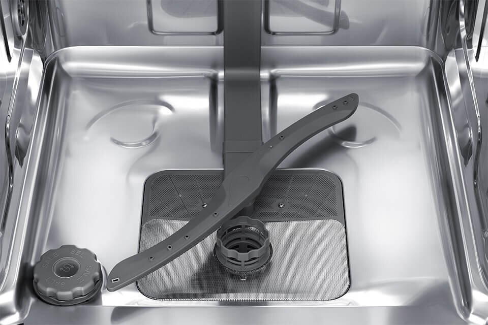 Wnętrze zmywarki z widocznym ramieniem spryskującym i filtrem. Elementy wykonane są z metalu i tworzywa sztucznego.