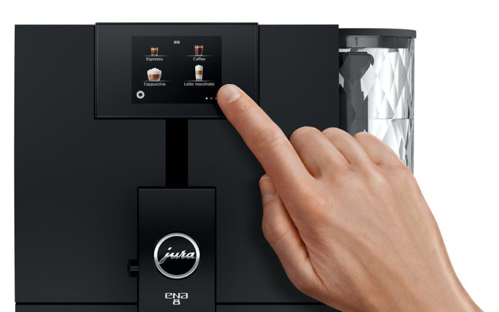 Czarny ekspres do kawy z dotykowym panelem, na którym widoczne są opcje: Espresso, Coffee, Cappuccino, Latte macchiato. Logo \'jura\' oraz napis \'ENA 8\' znajdują się poniżej ekranu.