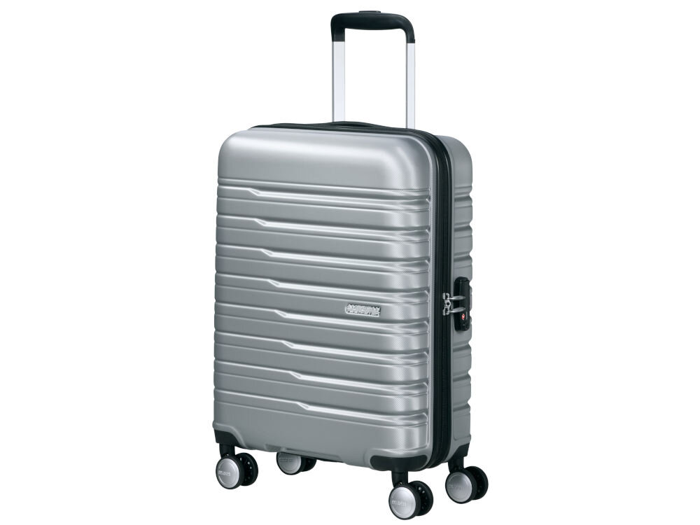 Srebrna walizka na czterech kółkach z wysuwaną rączką i poziomymi żłobieniami. Na powierzchni widoczne jest logo \'American Tourister\'.