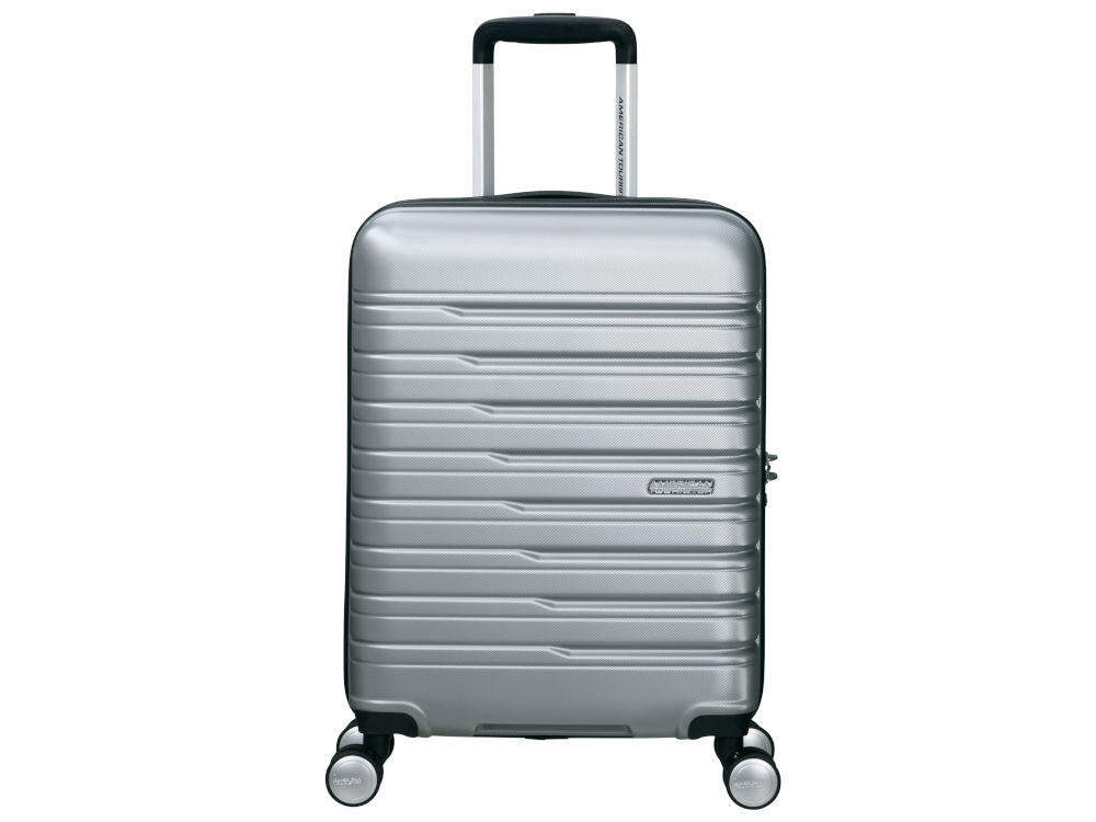 Srebrna walizka na czterech kółkach z teleskopową rączką i poziomymi żłobieniami. Na przodzie widoczne jest logo \'American Tourister\'.
