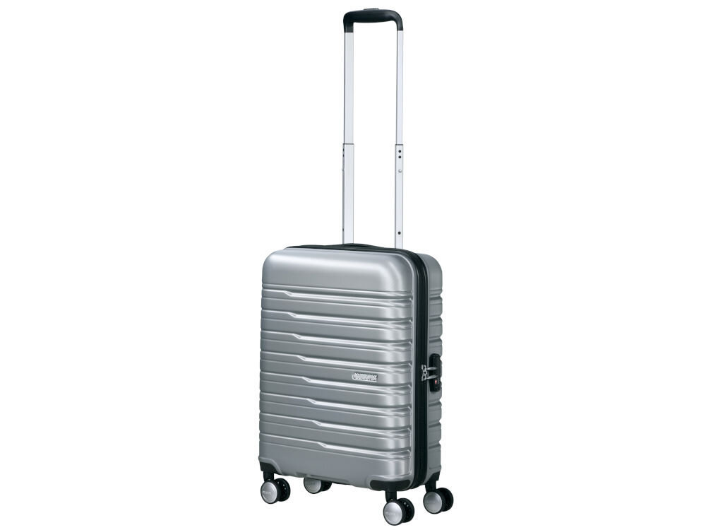 Srebrna walizka na kółkach z wysuwaną rączką, posiada logo \'American Tourister\'.