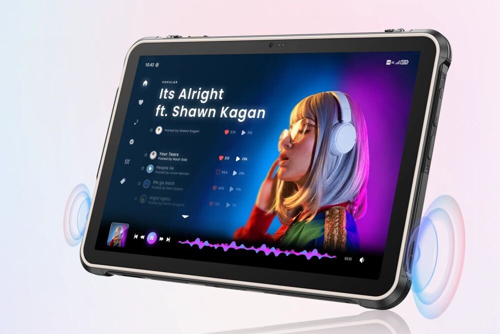 Tablet z wyświetlaczem pokazującym aplikację muzyczną z utworem \'Its Alright ft. Shawn Kagan\'. Na ekranie widoczna jest postać w słuchawkach oraz lista odtwarzania z ikonami serc i licznikami odtworzeń.