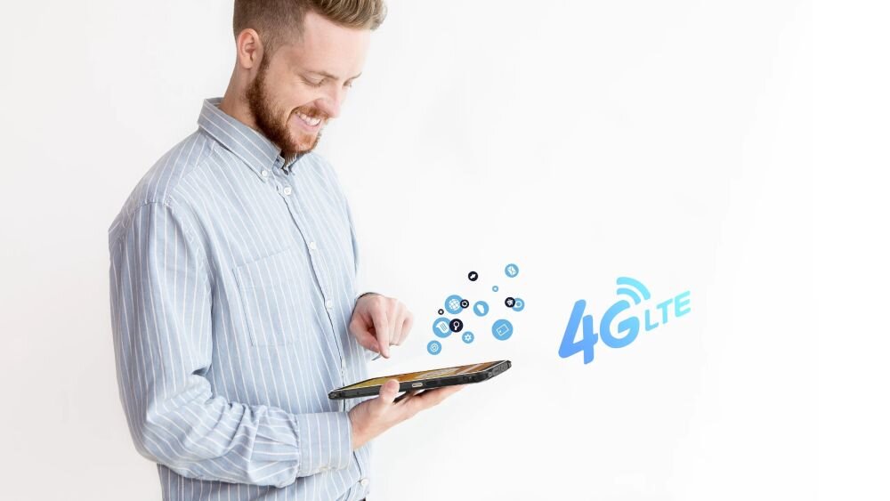 Osoba trzyma tablet, z którego unoszą się ikony aplikacji. Obok widoczny jest napis \'4G LTE\'.