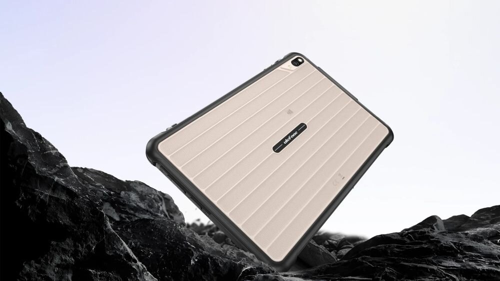 Tablet z jasną, żebrowaną obudową i ciemnymi krawędziami, leży na tle skalistego krajobrazu. Na obudowie widoczne jest logo \'ulefone\'.