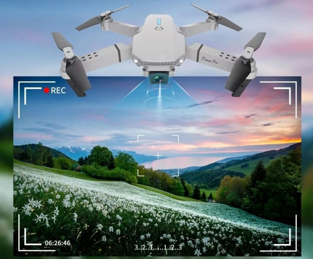 Na obrazie widoczny jest dron z rozłożonymi śmigłami, unoszący się nad krajobrazem górskim z kwitnącą łąką. Na ekranie widoczne są elementy interfejsu kamery, takie jak \'REC\' i liczby \'06:26:46\'.