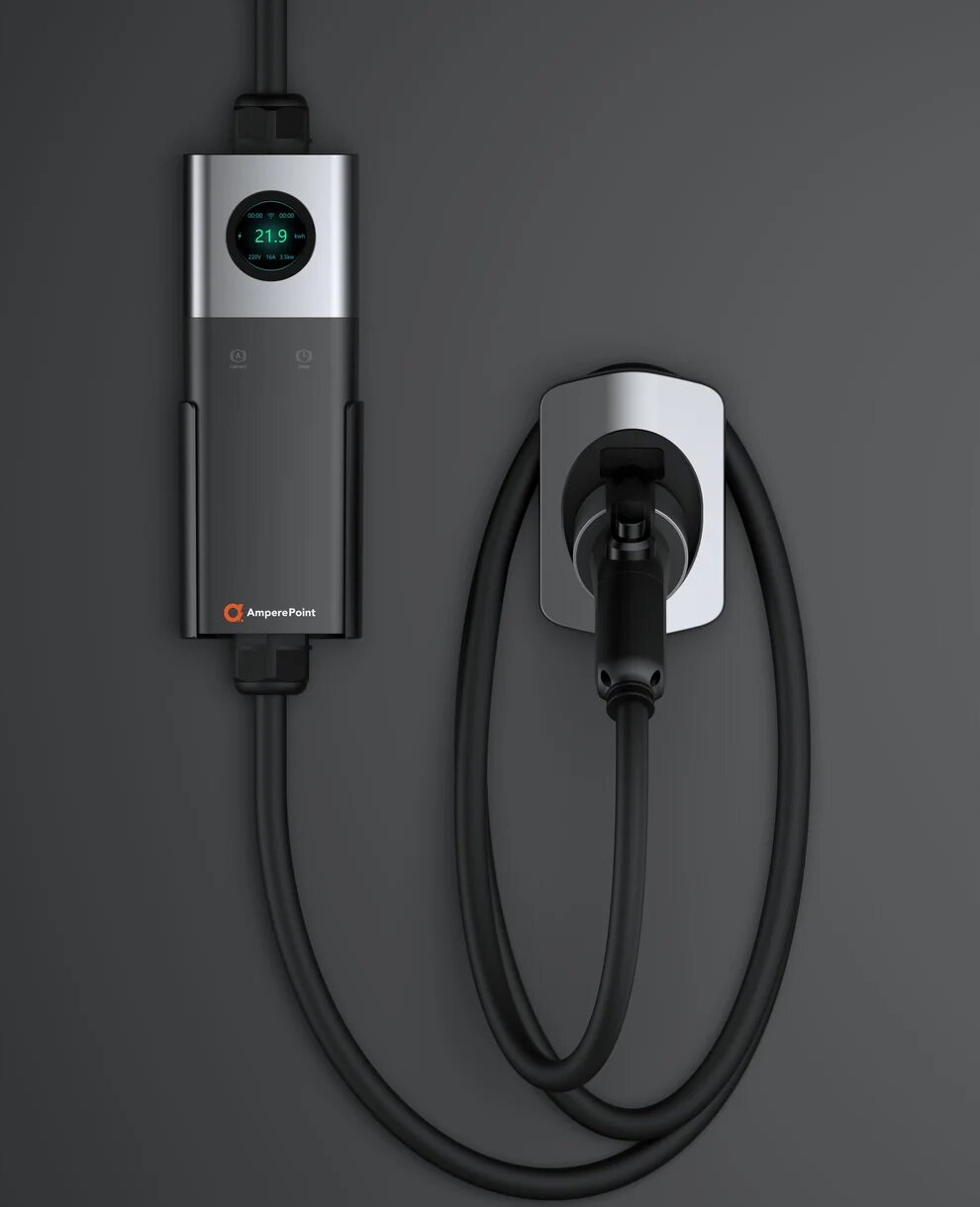 Na obrazie widoczna jest przenośna ładowarka do aut elektrycznych z wyświetlaczem pokazującym \'21.9\'. Obok znajduje się kabel z wtyczką, a na urządzeniu widnieje logo \'AmperePoint\'.