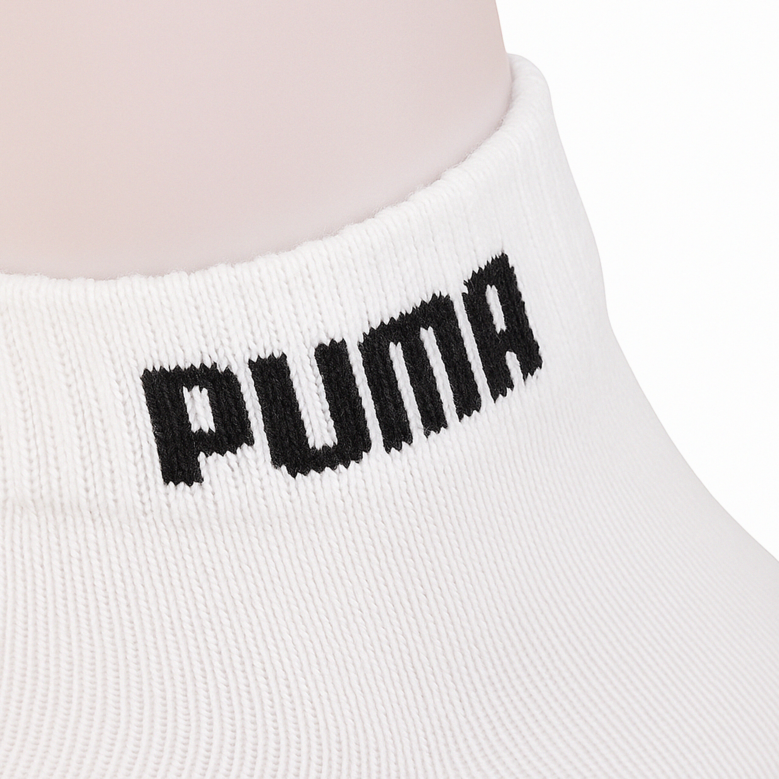 Biała skarpeta z widocznym czarnym napisem \'PUMA\' na ściągaczu.