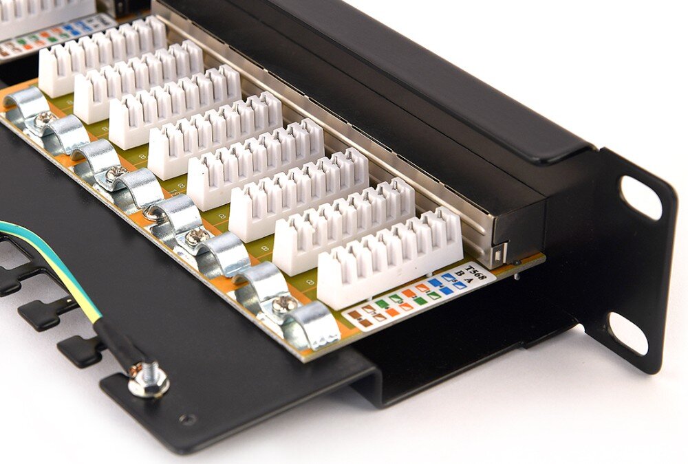 Patch panel ENERGENIE NPP-C624-002 Zbliżenie na białe bloki zaciskowe i metalowe klamry montażowe, obok których umieszczono naklejkę z kodami kolorystycznymi standardów T568A oraz T568B