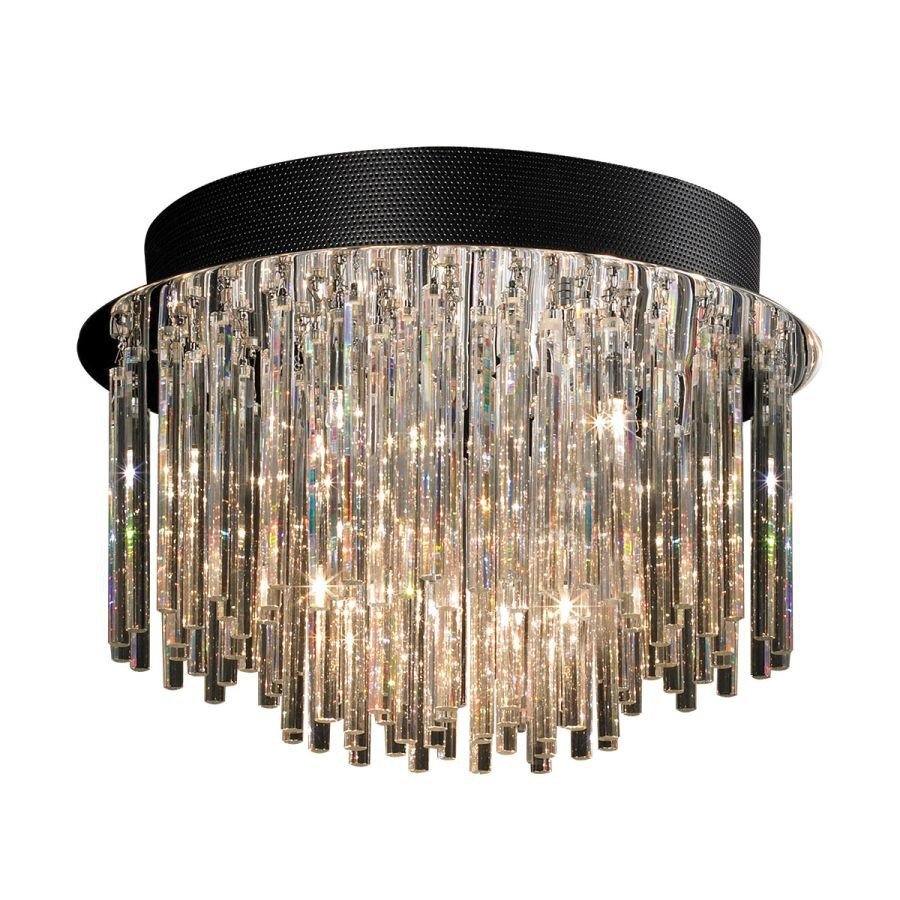 Lampa sufitowa złożona z licznych, pionowych, szklanych elementów, które odbijają światło, tworząc efektowne refleksy. Górna część lampy jest czarna i ma teksturowaną powierzchnię.
