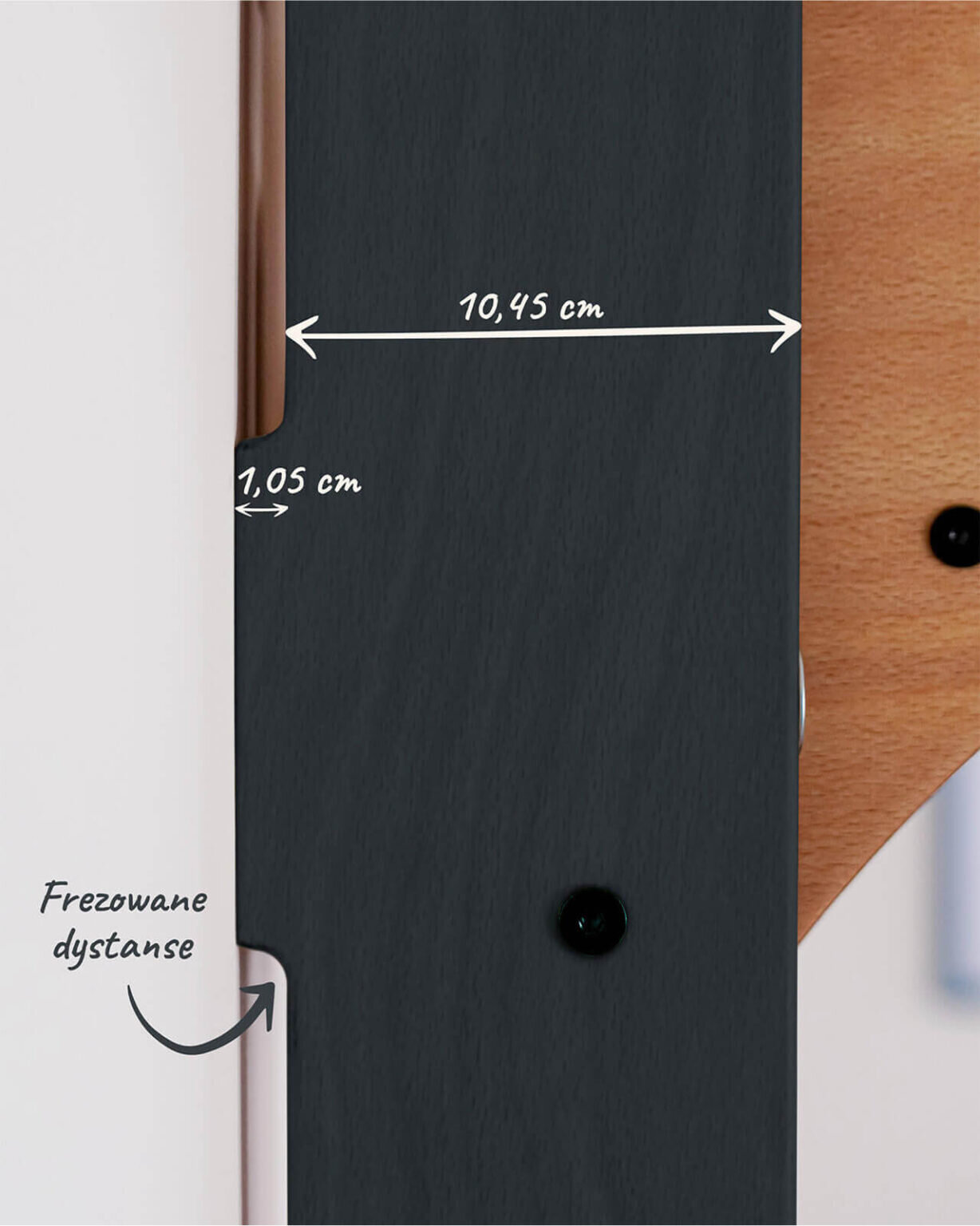 Zbliżenie na fragment drabinki gimnastycznej z oznaczeniami wymiarów: 10,45 cm i 1,05 cm. Widoczny jest napis \'Frezowane dystanse\'.