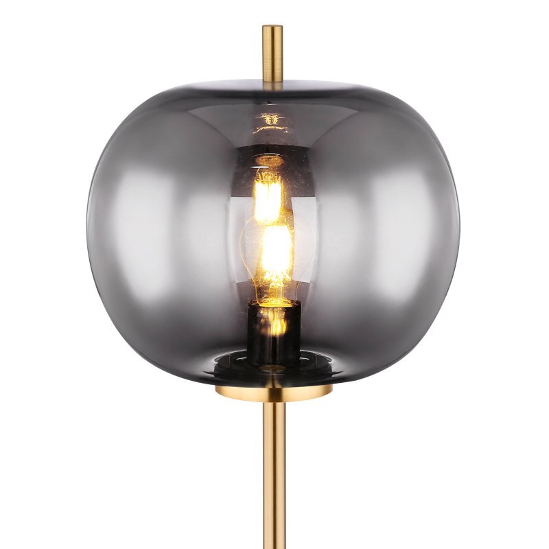 Lampa podłogowa z czarnym, matowym kloszem z metalu i szkła, z widoczną żarówką wewnątrz. Posiada złoty element konstrukcyjny i włącznik nożny.