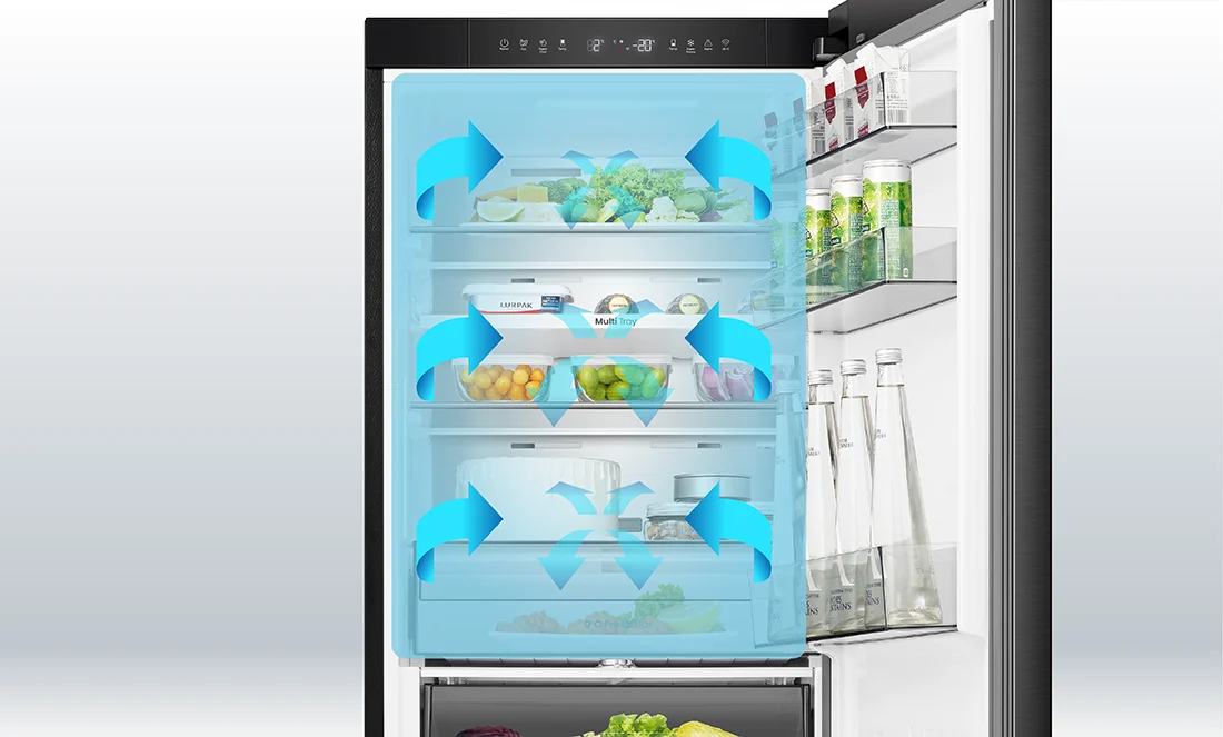 Wnętrze lodówki z widocznymi półkami wypełnionymi różnymi produktami spożywczymi, takimi jak warzywa, napoje i nabiał. Na drzwiach lodówki znajdują się dodatkowe półki z napojami, a na środku widoczne są niebieskie strzałki wskazujące na cyrkulację powietrza.
