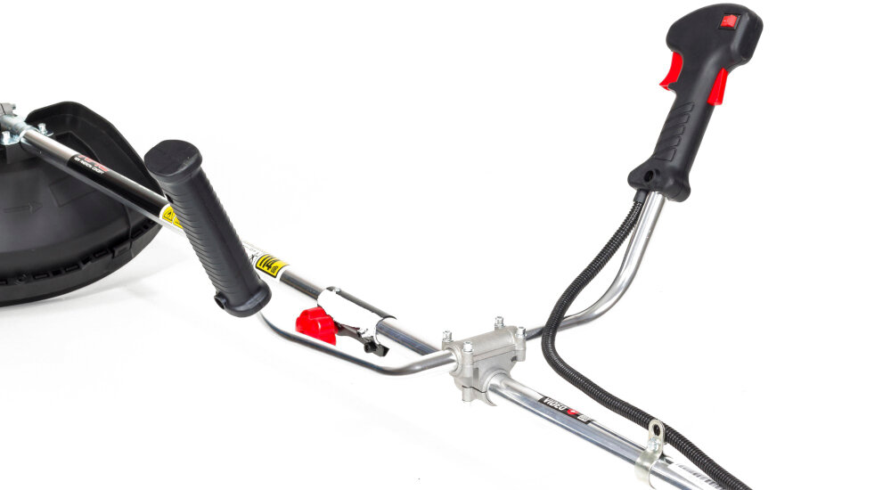 Fragment kosy spalinowej z widocznymi uchwytami i elementami sterującymi. Uchwyt jest czarny z czerwonymi akcentami, a na metalowej rurze znajduje się napis \'TEXAS\'.