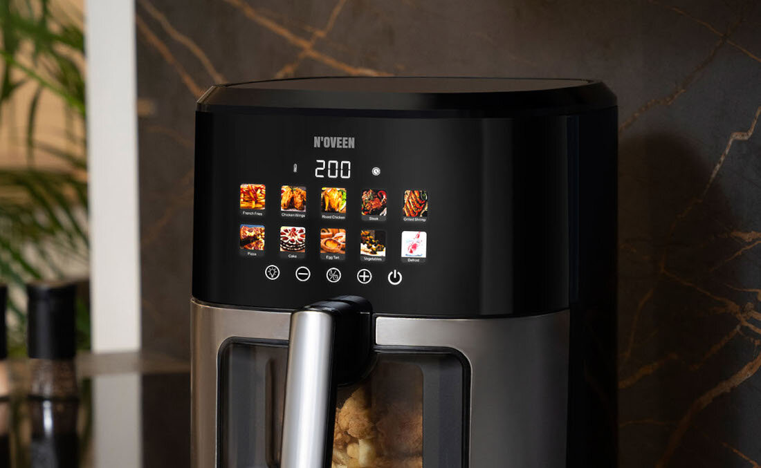 Na zdjęciu widoczna jest frytkownica beztłuszczowa NOVEEN z wyświetlaczem pokazującym temperaturę 200 stopni oraz różne ikony programów gotowania. Logo \'NOVEEN\' znajduje się nad wyświetlaczem.