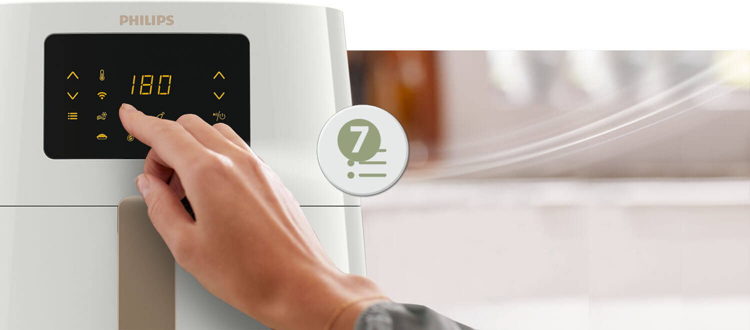 Osoba dotyka panelu sterowania frytkownicy beztłuszczowej z wyświetlaczem pokazującym \'180\'. Widoczne jest logo \'PHILIPS\' oraz ikona z cyfrą \'7\'.